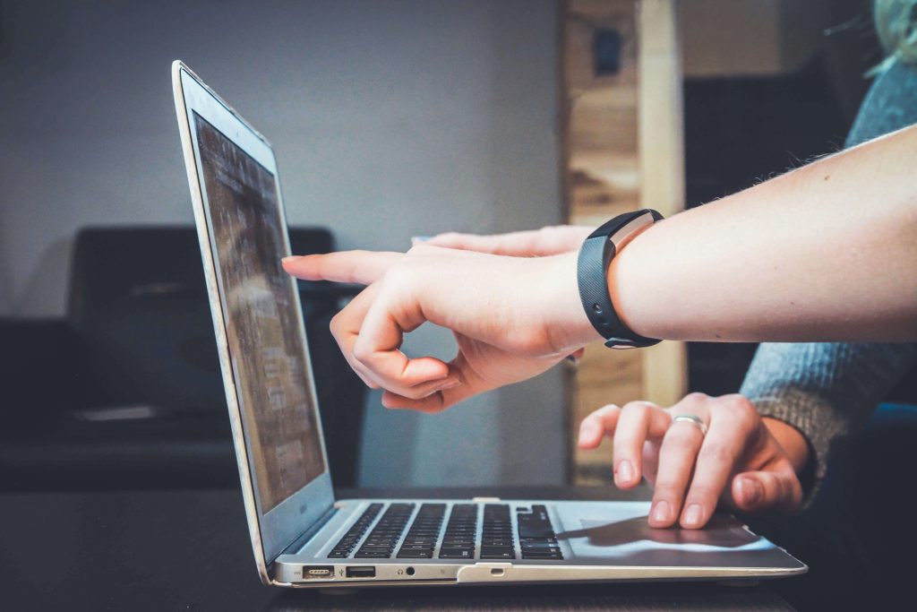 Hands typing on a laptop keyboard during business work