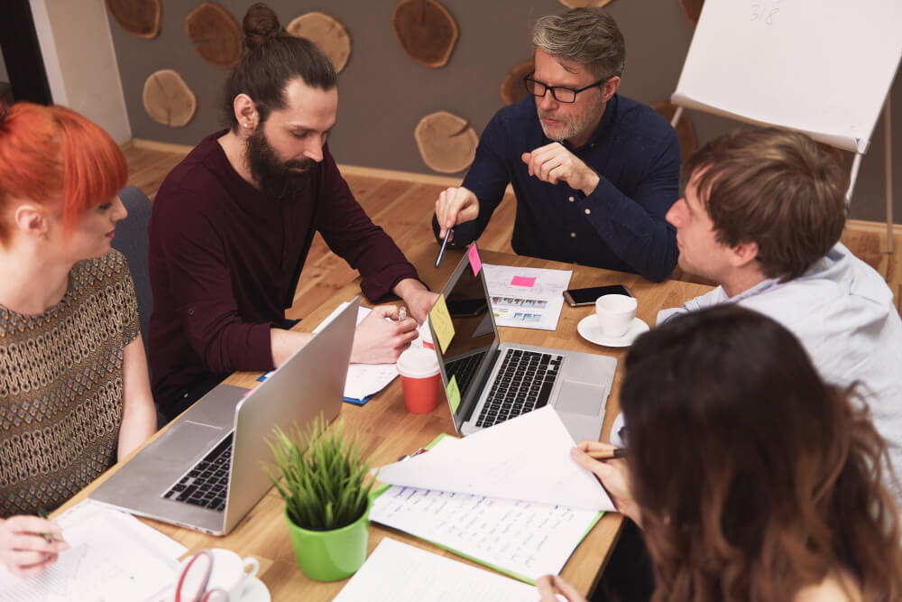 Sydney small business owner planning weekly social media posts on a notebook and laptop